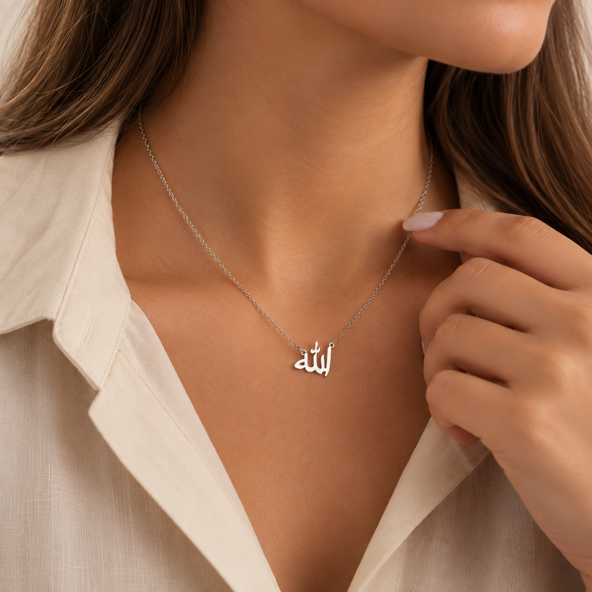 Collier Allah argenté porté par une femme voilée